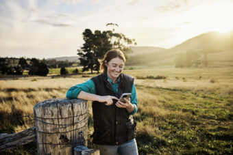 Female farmer with Mobile Phone in a paddock.